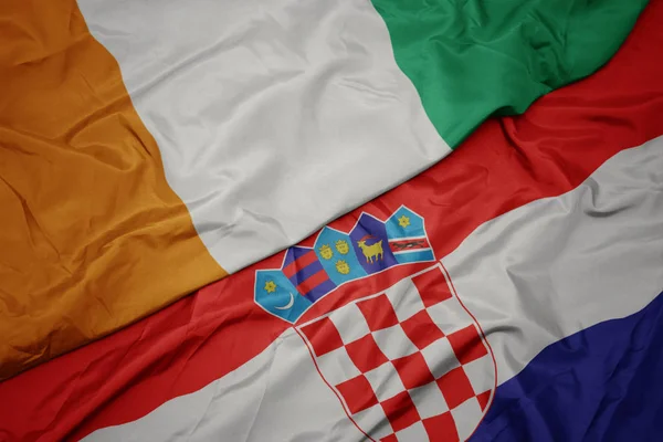 Mávající barevnou vlajkou Chorvatska a národní vlajkou Pobřeží slonoviny. — Stock fotografie