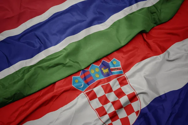 Mávání barevnou vlajkou Chorvatska a národní vlajka gamia. — Stock fotografie
