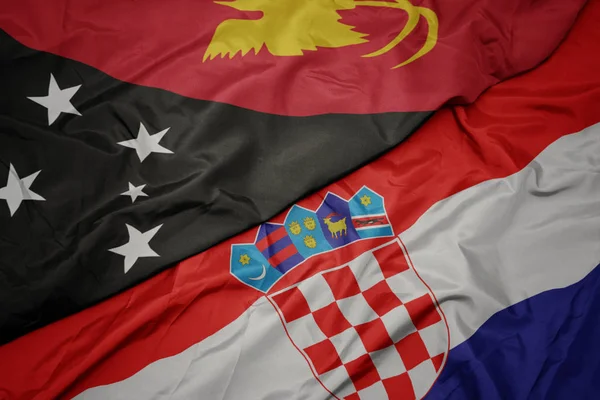 Ondeando colorida bandera de croacia y bandera nacional de Papúa Nueva Guinea — Foto de Stock