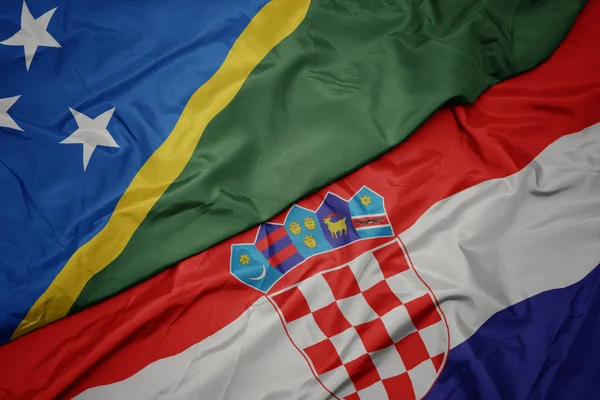 Ondeando colorida bandera de croacia y bandera nacional de Islas Salomón  . — Foto de Stock