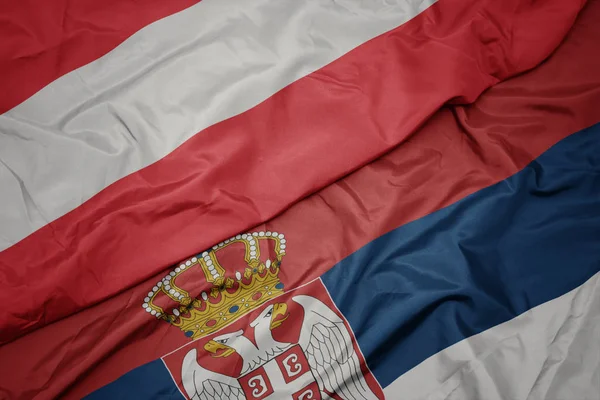 セルビアのカラフルな旗やオーストリアの国旗を振って. — ストック写真