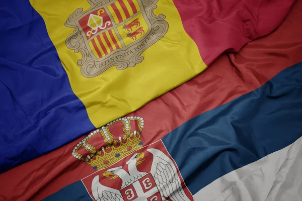 Ondeando colorida bandera de serbia y bandera nacional de andorra . —  Fotos de Stock