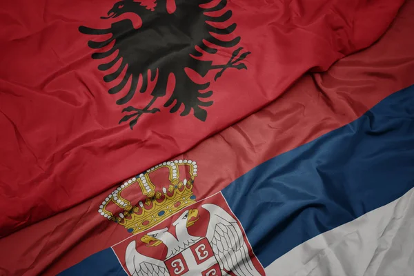 waving colorful flag of serbia and national flag of albania.