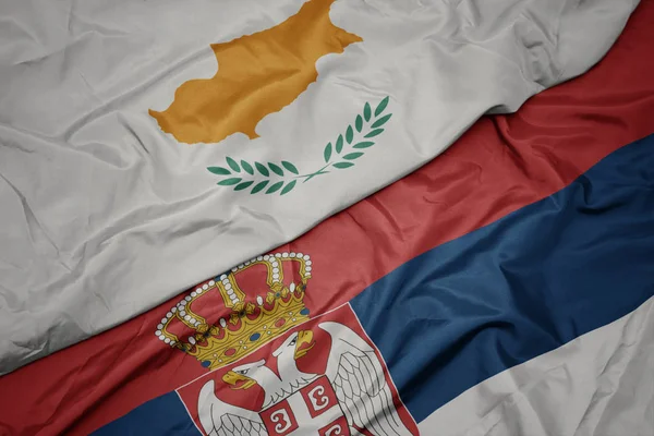 waving colorful flag of serbia and national flag of cyprus.