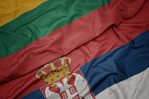 Színes szerb zászló lobogtatása és lituánia nemzeti zászlója. — Stock Fotó