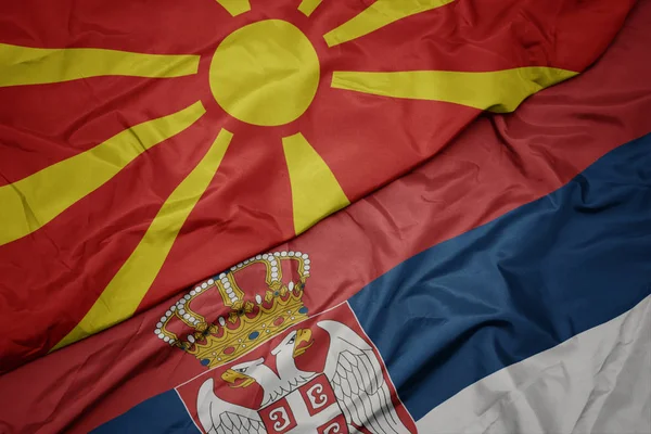 Acenando bandeira colorida da Sérvia e bandeira nacional da macedônia . — Fotografia de Stock