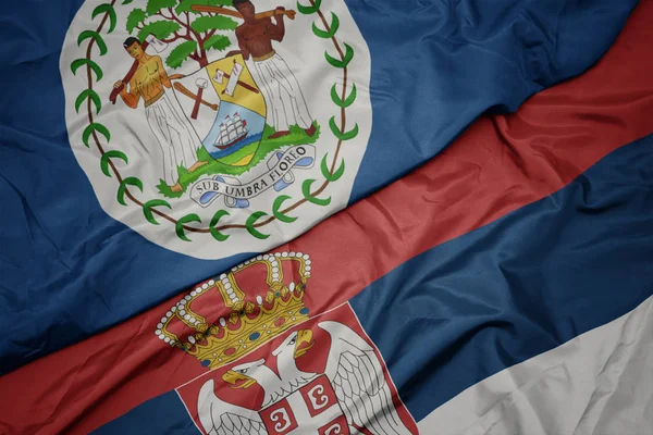 Κυματίζει πολύχρωμη σημαία της σερβίας και εθνική σημαία του belize. — Φωτογραφία Αρχείου