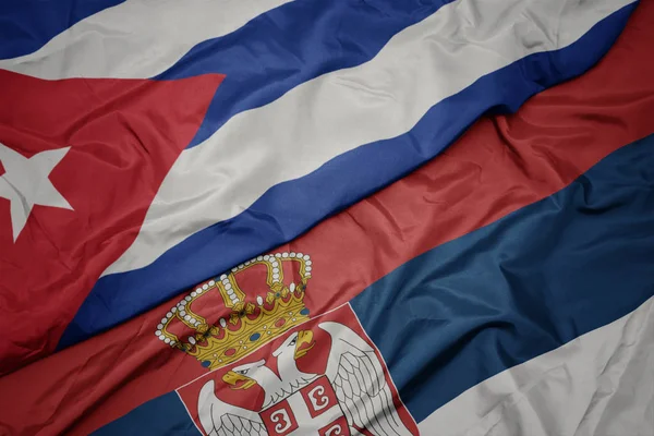 Mávání barevnou vlajkou Srbska a národní vlajkou Kuby. — Stock fotografie