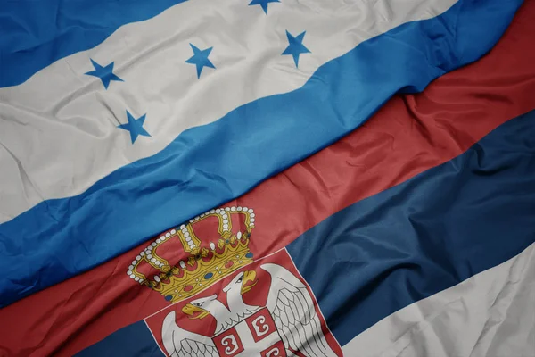 セルビアのカラフルな旗やホンジュラスの国旗を振って. — ストック写真