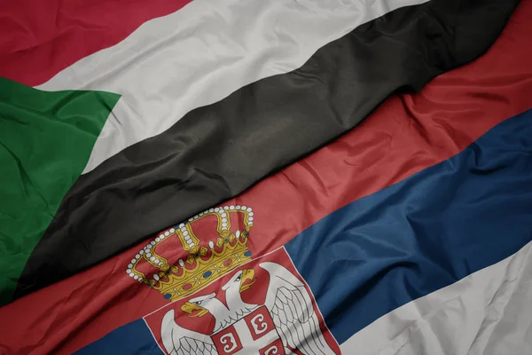 セルビアのカラフルな旗とスーダンの国旗を振って. — ストック写真