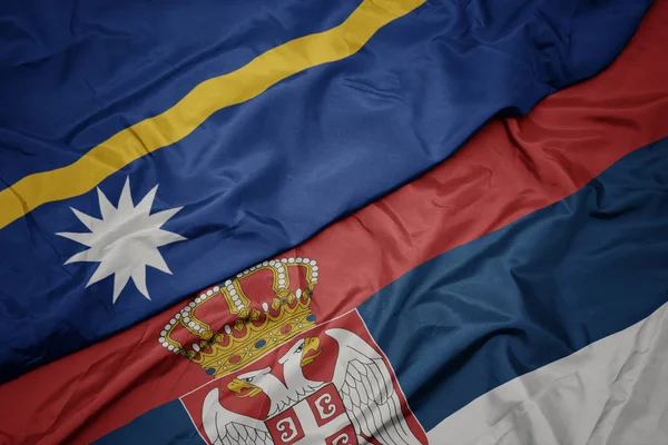 waving colorful flag of serbia and national flag of Nauru .