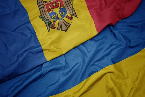 Ondeando colorida bandera de Ucrania y bandera nacional de Moldavia . —  Fotos de Stock