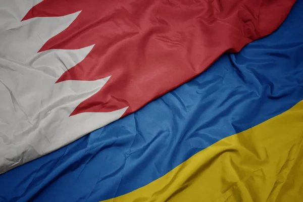 Waving colorful flag of ukraine and national flag of bahrain. — ストック写真