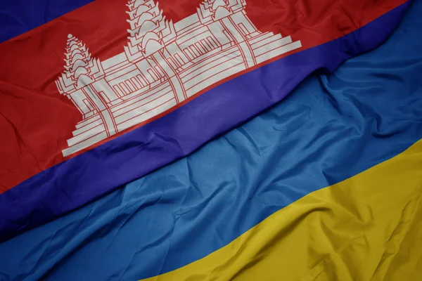 Acenando bandeira colorida de ucraniano e bandeira nacional de cambodia . — Fotografia de Stock