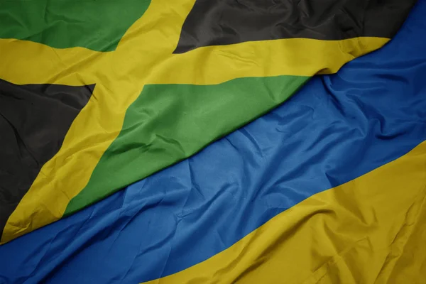 Waving colorful flag of ukraine and national flag of jamaica. — Stock Photo, Image
