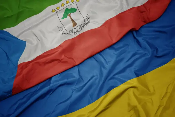 Ondeando colorida bandera de Ucrania y bandera nacional de Guinea Ecuatorial . —  Fotos de Stock