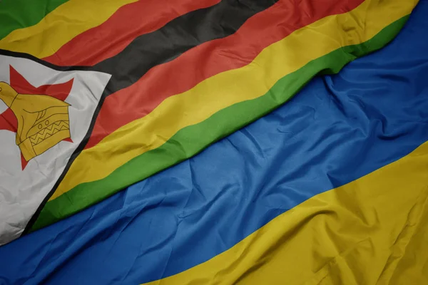 Махаючи різнокольоровим прапором України та національного прапора Зімбабве . — стокове фото