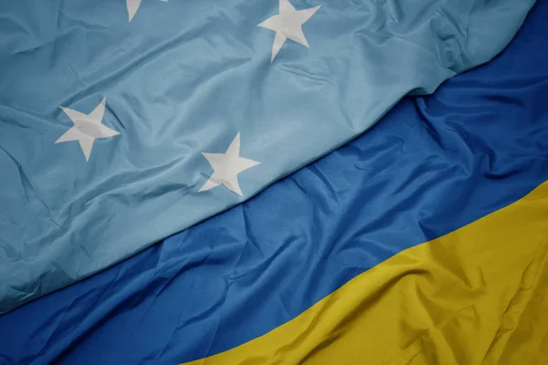 Waving colorful flag of ukraine and national flag of Federated States of Micronesia . — ストック写真