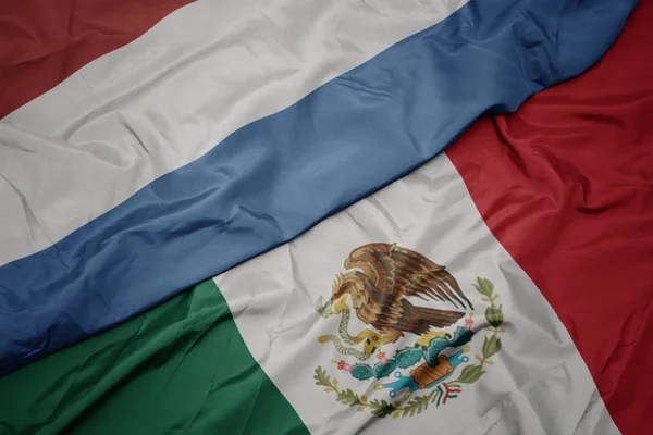 Waving colorful flag of mexico and national flag of luxembourg. macro — Stock Photo, Image