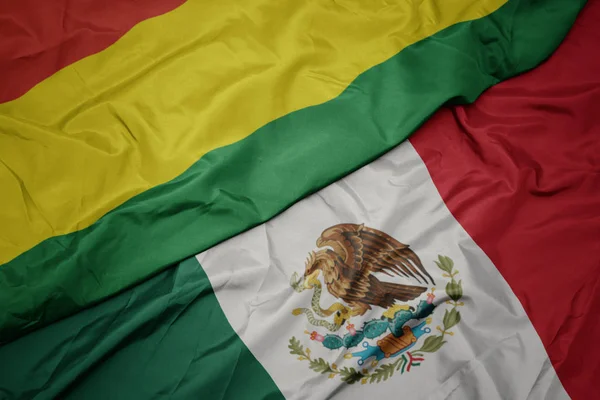 Színes mexikói zászlót lobogtatva és Bolívia nemzeti zászlaját lobogtatva. makroszintű — Stock Fotó