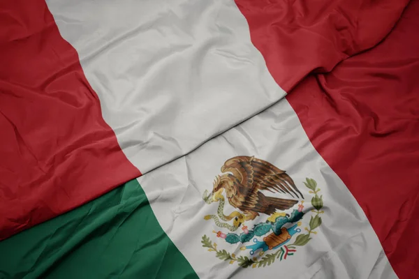 Agitant drapeau coloré du Mexique et drapeau national du Pérou. macro — Photo