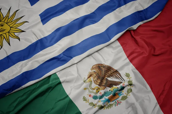 Waving colorful flag of mexico and national flag of uruguay. macro — Stock Photo, Image