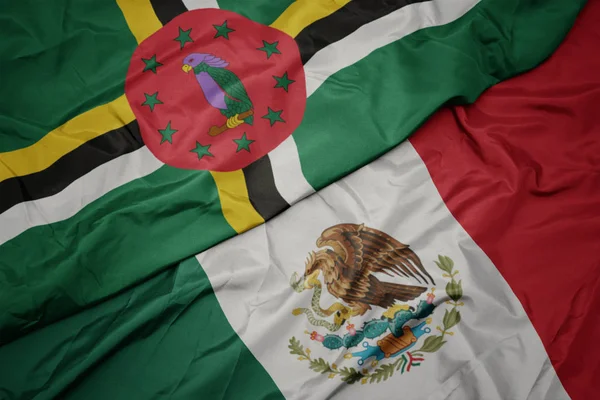 Machając barwną flagą Meksyku i narodową flagą Dominiki. makro — Zdjęcie stockowe