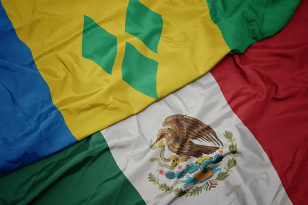 Waving colorful flag of mexico and national flag of saint vincent and the grenadines. macro — Stock Photo, Image