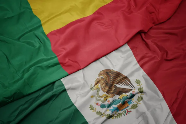 Waving colorful flag of mexico and national flag of benin. macro — Stock Photo, Image