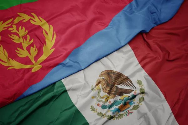 Ondeando colorida bandera de México y bandera nacional de eritrea. macro — Foto de Stock