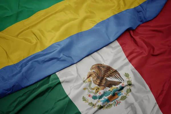 Ondeando colorida bandera de México y bandera nacional de Gabón. macro —  Fotos de Stock