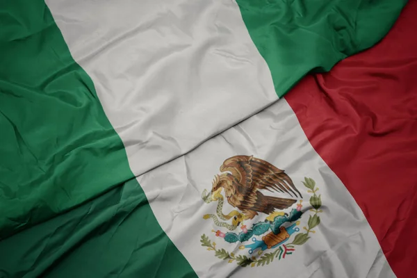 Waving colorful flag of mexico and national flag of nigeria. macro — Stock Photo, Image