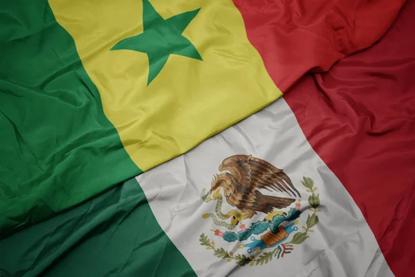 Viftande färgglada flagga mexikanska och nationella flagga Senegal. makro — Stockfoto