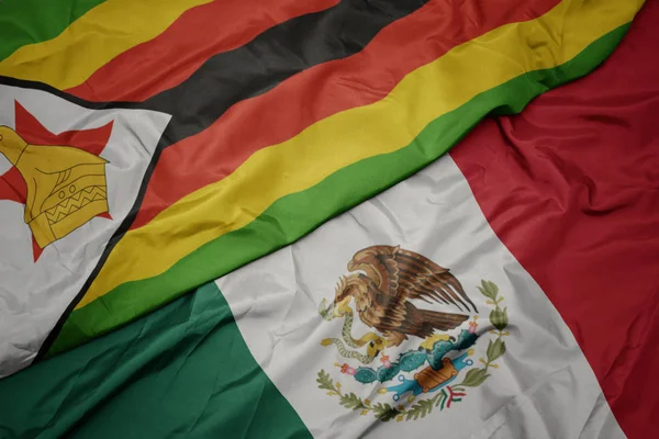 Waving colorful flag of mexico and national flag of zimbabwe. macro — Stockfoto