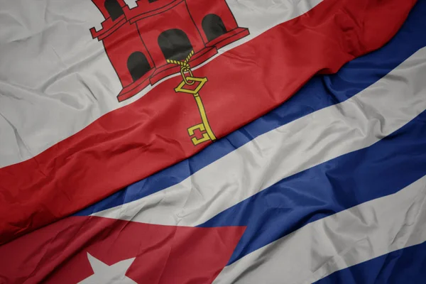 Mávání barevnou vlajkou Kuby a národní vlajkou gibraltaru. — Stock fotografie
