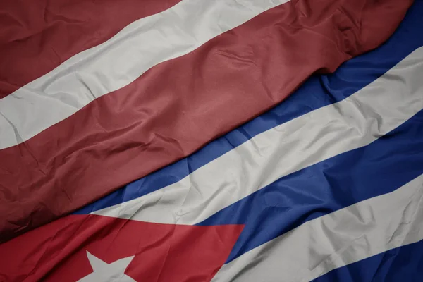 Lengető színes zászló Kuba és a nemzeti zászló latvia. — Stock Fotó
