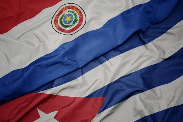 Agitant drapeau coloré de cuba et drapeau national du paraguay . — Photo