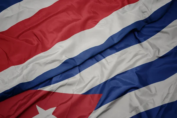 Размахивая красочным флагом Кубы и национальным флагом Коста-Рики . — стоковое фото