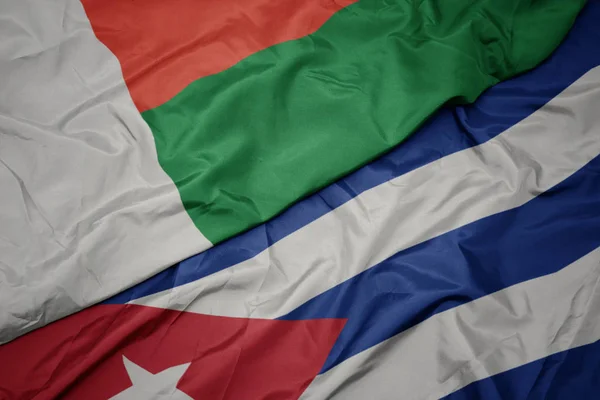Ondeando colorida bandera de cuba y bandera nacional de madagascar . —  Fotos de Stock