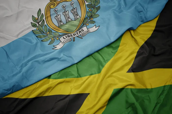 Jamaika 'nın renkli bayrağı ve San Marino' nun ulusal bayrağı sallanıyor.. — Stok fotoğraf
