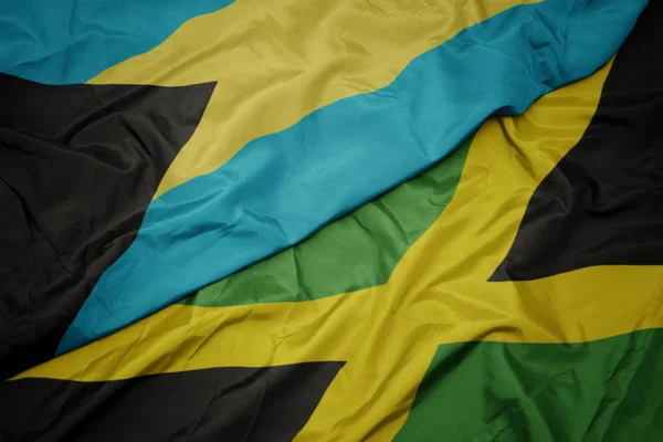 Ondeando colorida bandera de jamaica y bandera nacional de bahamas . —  Fotos de Stock