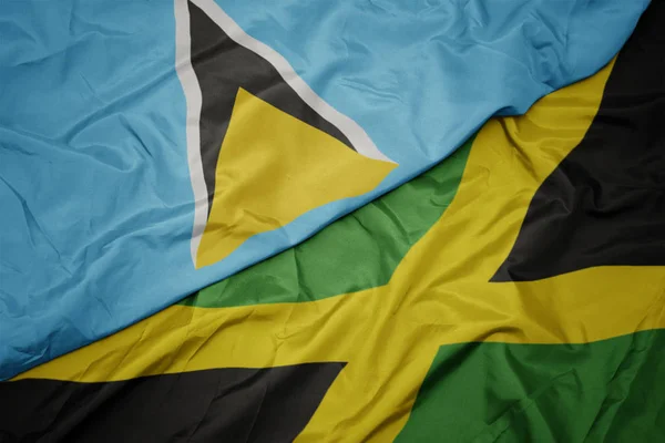 Agitant drapeau coloré de jamaica et drapeau national de Sainte-Lucie — Photo