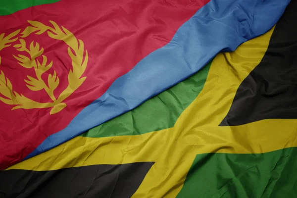 Mávání barevnou vlajkou Jamajky a národní vlajky eritreje. — Stock fotografie