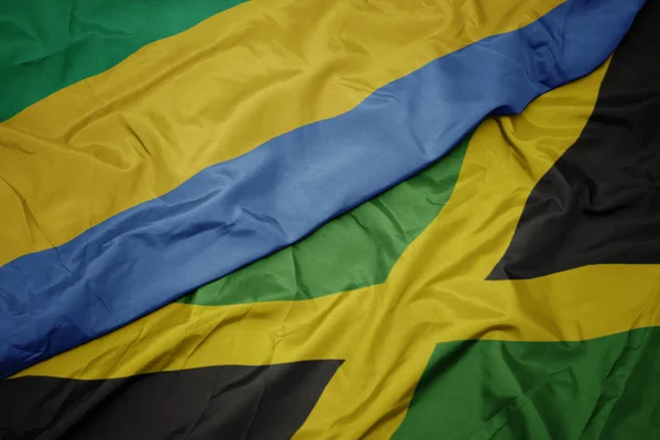 Κυματίζει πολύχρωμη σημαία της Τζαμάικα και εθνική σημαία της Γκαμπόν. — Φωτογραφία Αρχείου