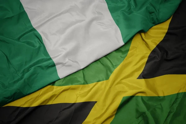 Waving colorful flag of jamaica and national flag of nigeria. — Stock Photo, Image