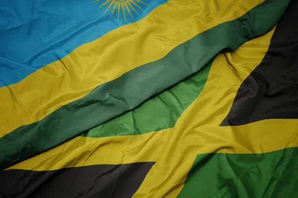 Ondeando colorida bandera de jamaica y bandera nacional de rwanda . —  Fotos de Stock