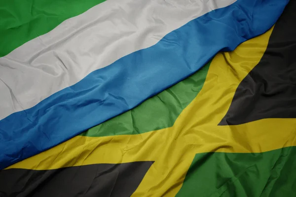 Acenando bandeira colorida de jamaica e bandeira nacional de sierra leone . — Fotografia de Stock