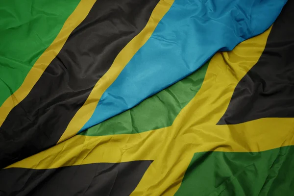 Ondeando colorida bandera de jamaica y bandera nacional de tanzania . —  Fotos de Stock