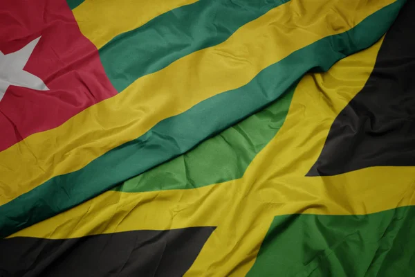 Ondeando colorida bandera de jamaica y bandera nacional de togo . —  Fotos de Stock