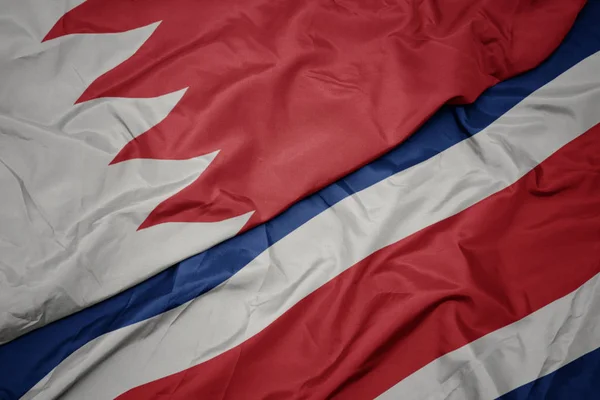 waving colorful flag of costa rica and national flag of bahrain.